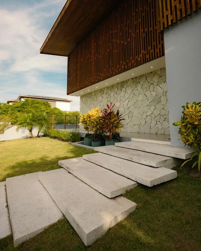 Child running along a garden path beside a timber-clad wall