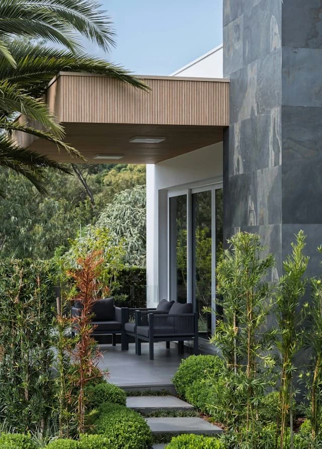 Sunlit vertical cladding with planting at its base